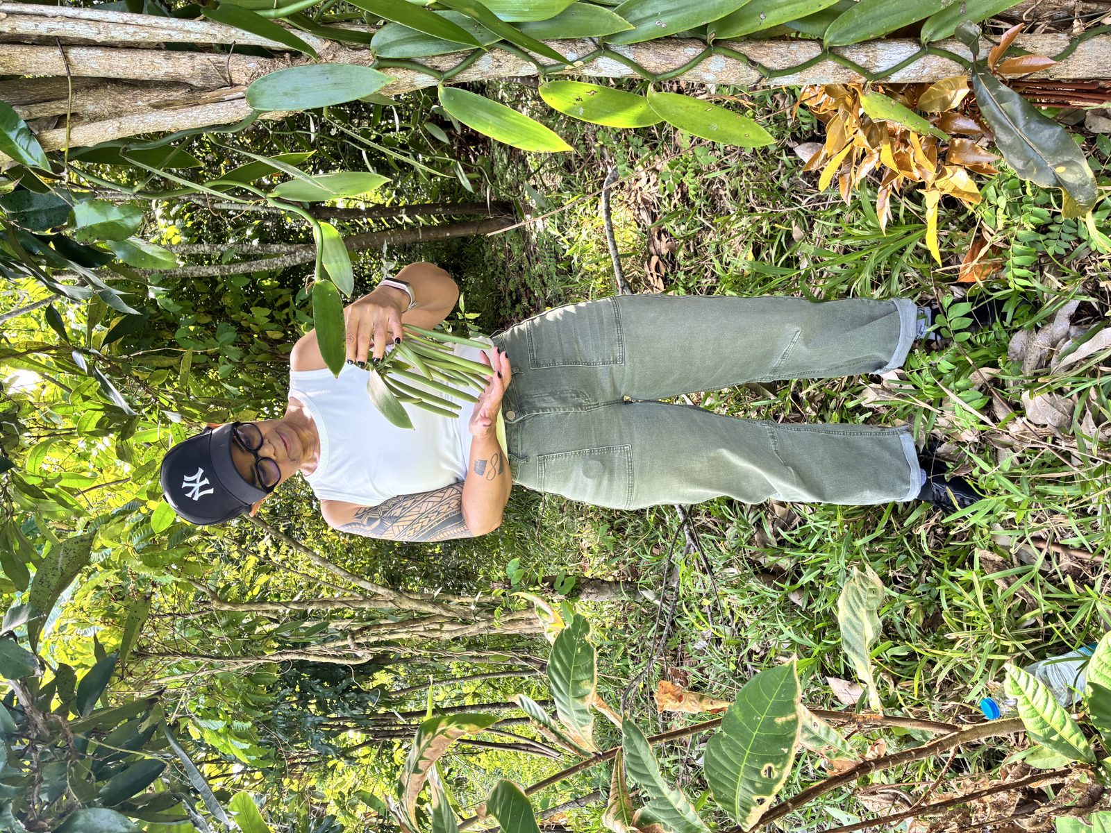A vanilla producer holding freshly harvested green vanilla pods in Sambava, Madagascar